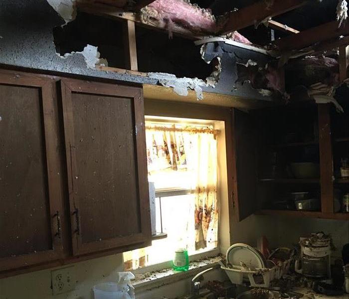 burned ceiling, debris on countertops and blackened cupboard